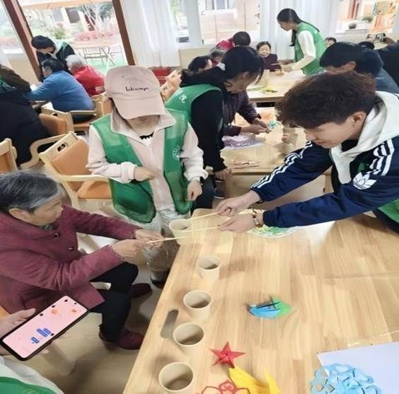 图为实志部同学在与老人做游戏