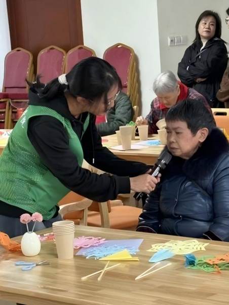 图为实志部同学在与老人唱红歌